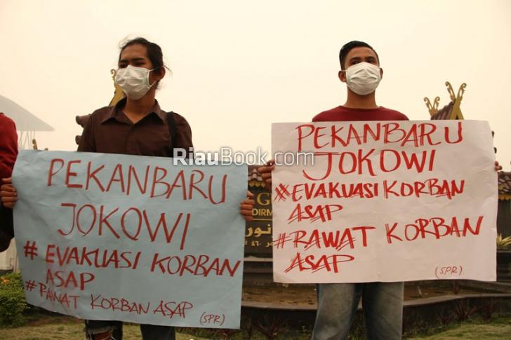 Berdiam Diri, Pakai Masker Bawa Poster Tolong Evakuasi Korban Asap
